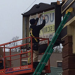 Man Working On Sign